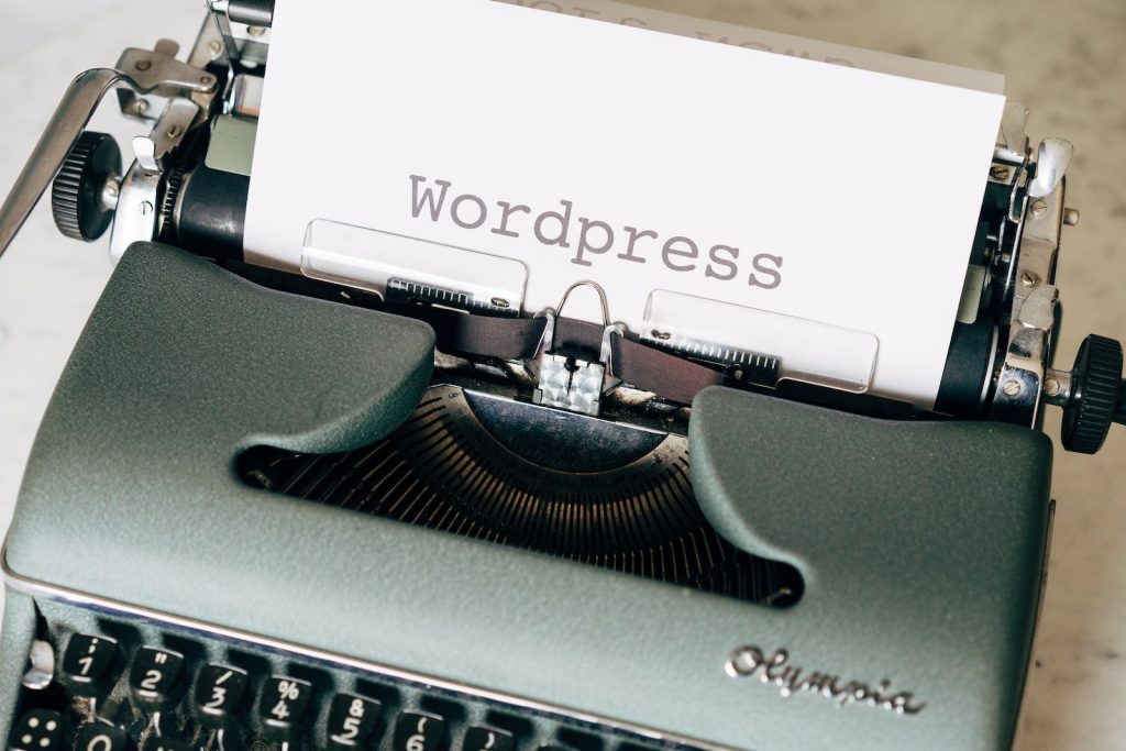 White Printer Paper on a Vintage Typewriter with the word: "Wordpress" typed in bold letters.
