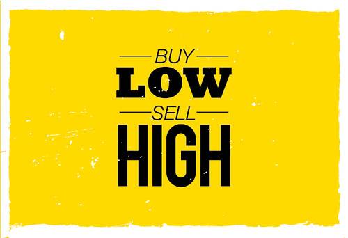 Yellow sign which reads: Buy Low, Sell High.