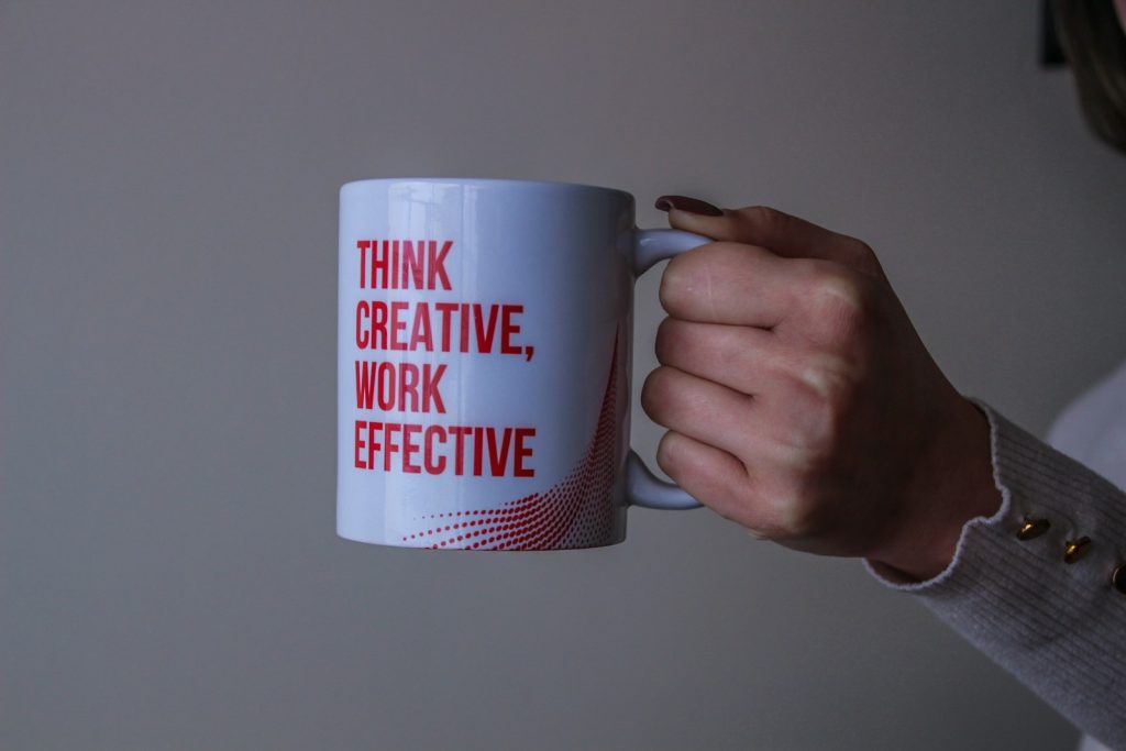 white and red ceramic mug "ThinkCreative, Work Effective".